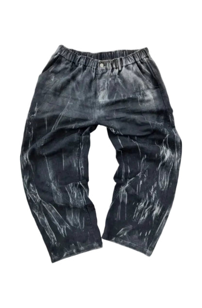 Black pants with a textured pattern on a gray surface